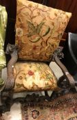 An 18th Century Continental oak framed hall chair or throne chair with long stitch needlework