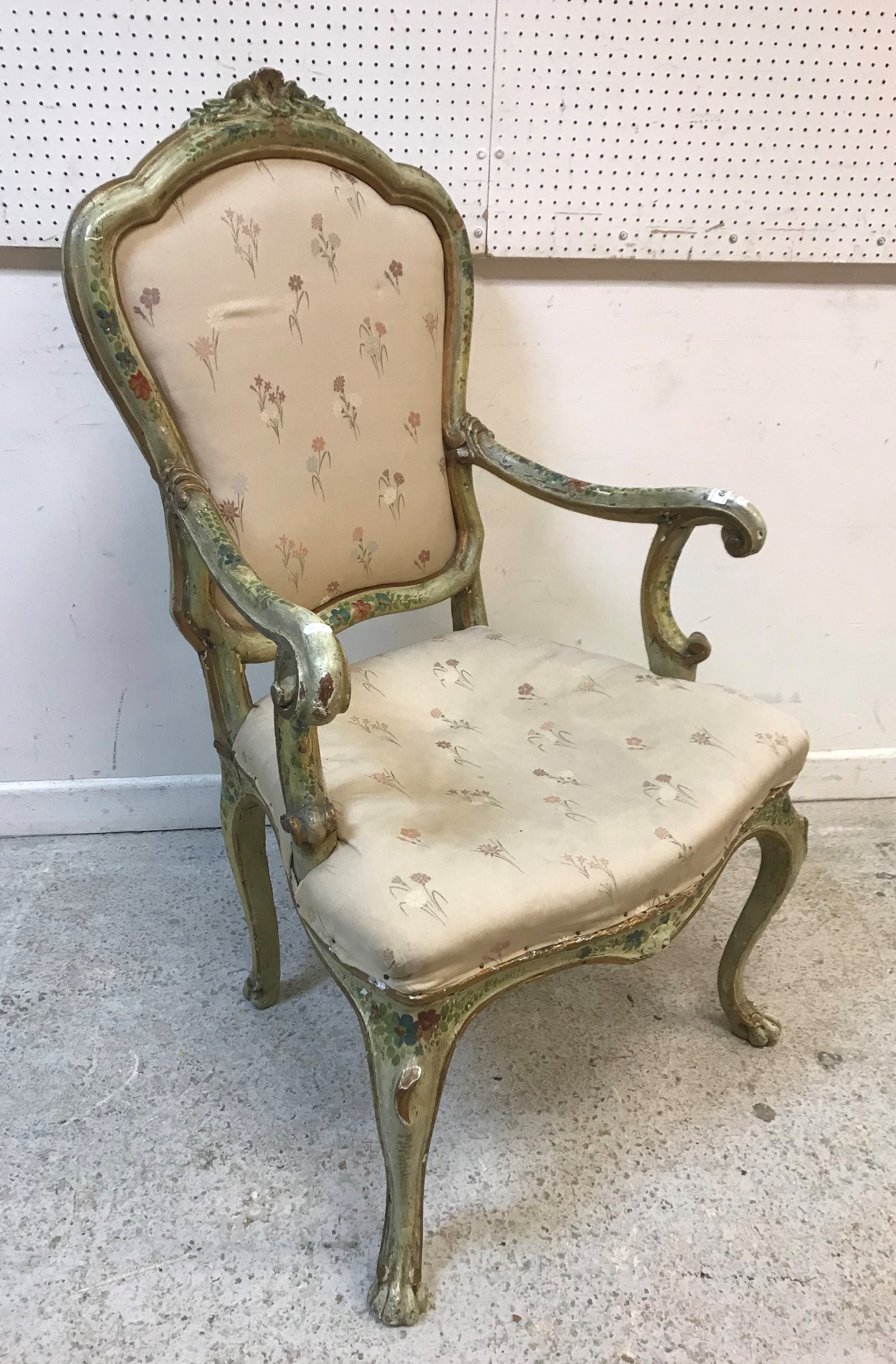 An 18th Century Italian painted elbow chair with all-over floral spray decoration and later