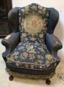 A circa 1900 upholstered wingback scroll arm chair in the Georgian style,