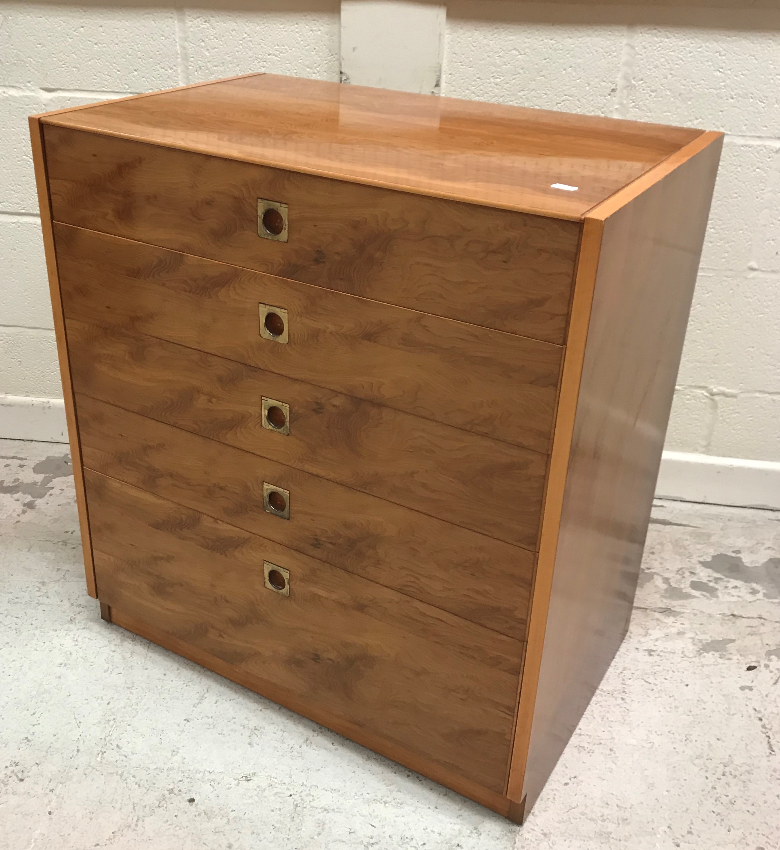 A 1960's yew wood chest of five long graduated drawers with brass flush handles,