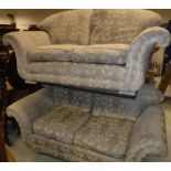 A pair of scroll arm two seat sofas in gold floral decorated upholstery,
