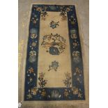 A circa 1920's Chinese rug, the central panel set with floral sprays on a cream ground,