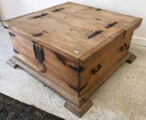 A modern pine box coffee table with two rising lids and wrought iron hinges and handles,