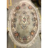 A Chinese superwash oval rug, the pale ground set with floral design,