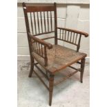 A late 19th Century stained beech framed rush seat spindle back Sussex type armchair after the