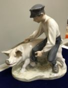 A Royal Copenhagen figure of a boy and pig (no.