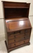 A circa 1900 mahogany bureau with shelved superstructure over a sloping fall enclosing a pigeon