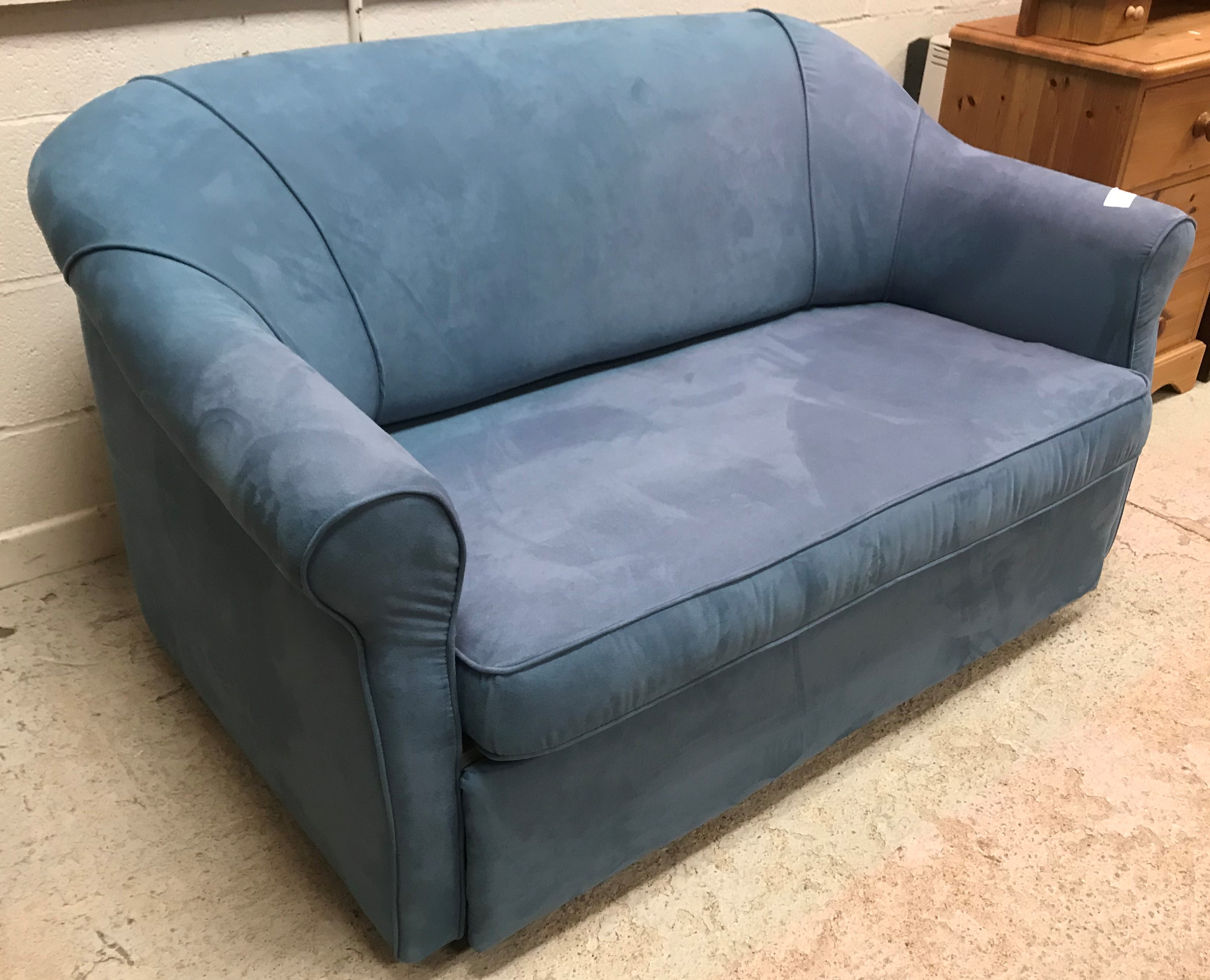 A modern blue suede effect two seat scroll arm bed settee or sofa bed,