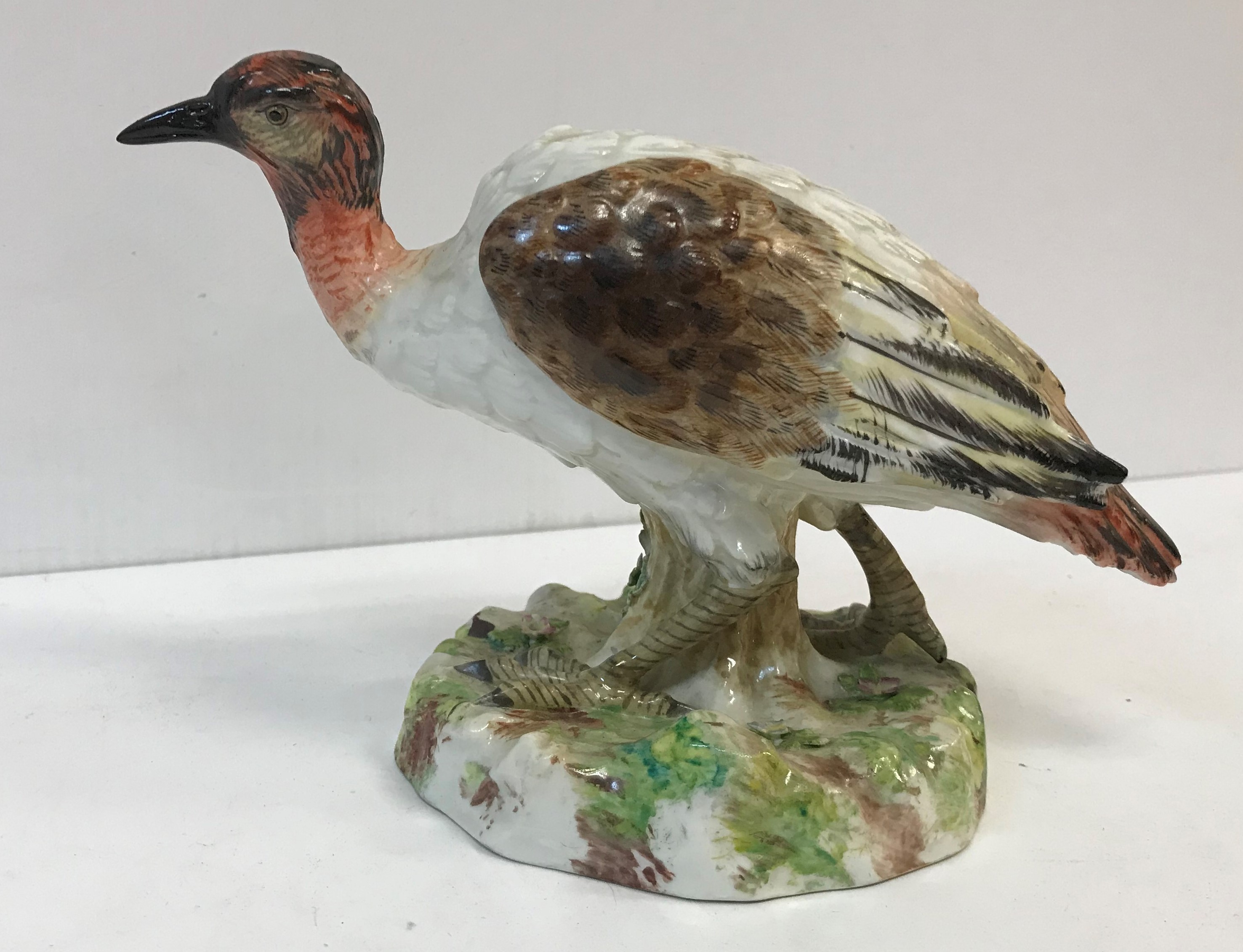 An early 19th Century Kändler style figure of an exotic bird on a mossy base,
