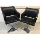 A pair of modern adjustable black and chrome bar chairs,