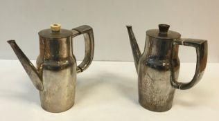 WITHDARWN : A pair of silver hot water jugs with hammered decoration and slender tapering spouts,