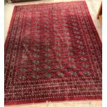 A modern Bokhara design rug with all-over elephant foot medallions on a plum ground,