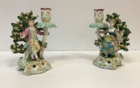 A pair of Samson bocage figural candlesticks as figures in 18th Century dress with dogs,