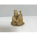 A Japanese Meiji Period netsuke as a seated lute-player (unsigned)