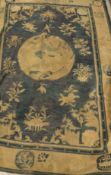 A Chinese carpet, the central panel set with animal and floral motifs on a blue ground,
