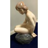 A Royal Copenhagen figure of naked girl seated upon a rock designed by Ada Bonfils, (no 4027) 13.