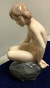 A Royal Copenhagen figure of naked girl seated upon a rock designed by Ada Bonfils, (no 4027) 13.