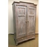A French pine armoire with two cupboard doors enclosing a hanging space over two drawers,
