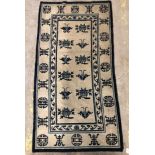 A Chinese rug, the central panel set with floral sprays on a cream ground,