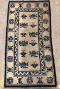 A Chinese rug, the central panel set with floral sprays on a cream ground,