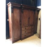 A Victorian mahogany triple wardrobe with central cupboard doors enclosing five linen shelves over