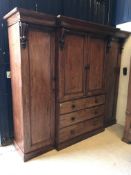 A Victorian mahogany triple wardrobe with central cupboard doors enclosing five linen shelves over