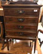 A 20th Century stained beech music chest of four drawers with fall fronts,