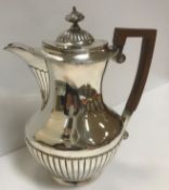 A Victorian silver hot water jug with semi-reeded decoration,