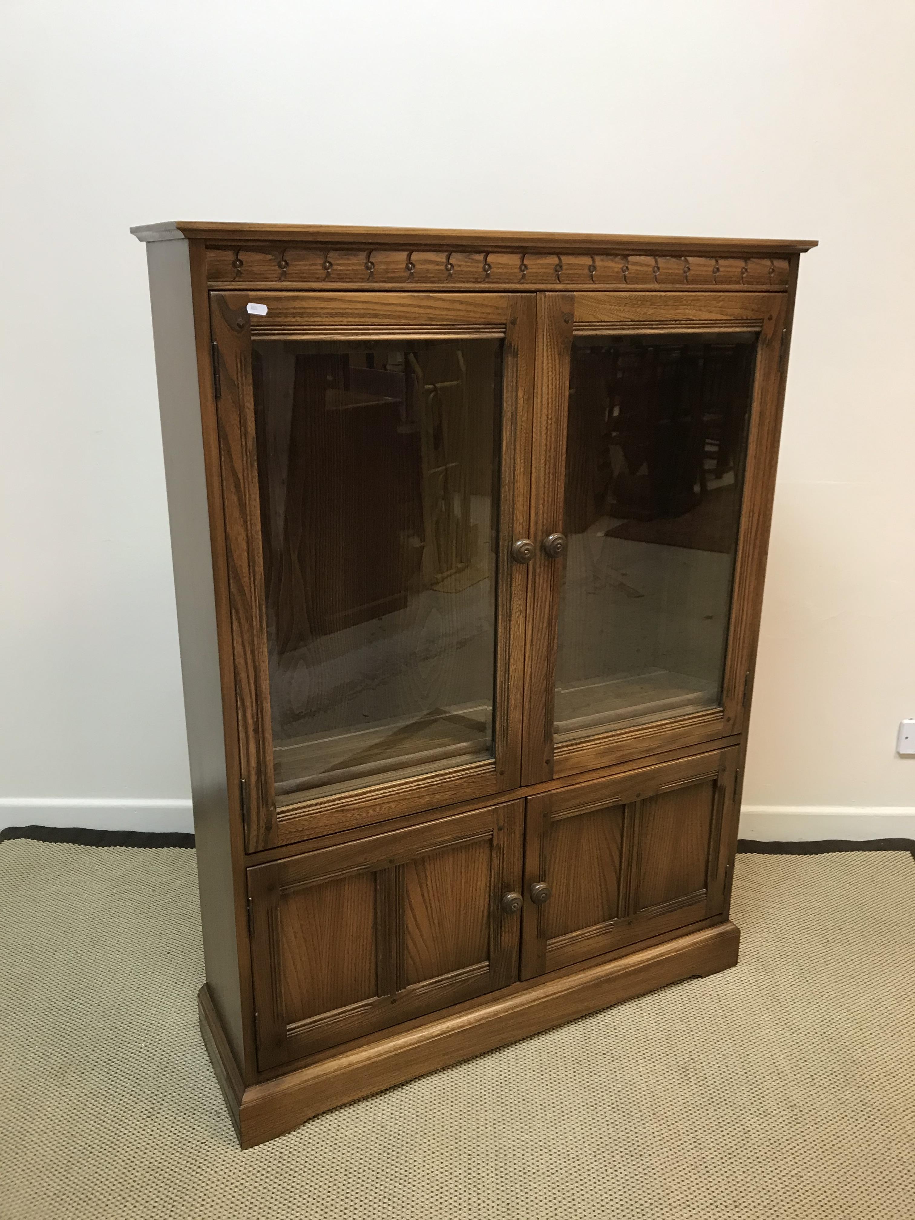 An Ercol elm side cabinet with two glazed cabinet doors enclosing two shelves over a recess, - Image 2 of 2