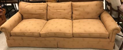 A modern fawn upholstered three-seat scroll-arm sofa,