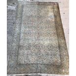 An Oriental carpet, the central panel set with all over floral decoration on a fawn ground,