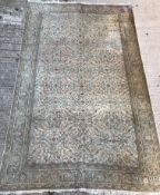 An Oriental carpet, the central panel set with all over floral decoration on a fawn ground,