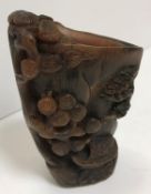 A 19th Century Chinese carved rhinoceros horn libation cup decorated with building by water's edge