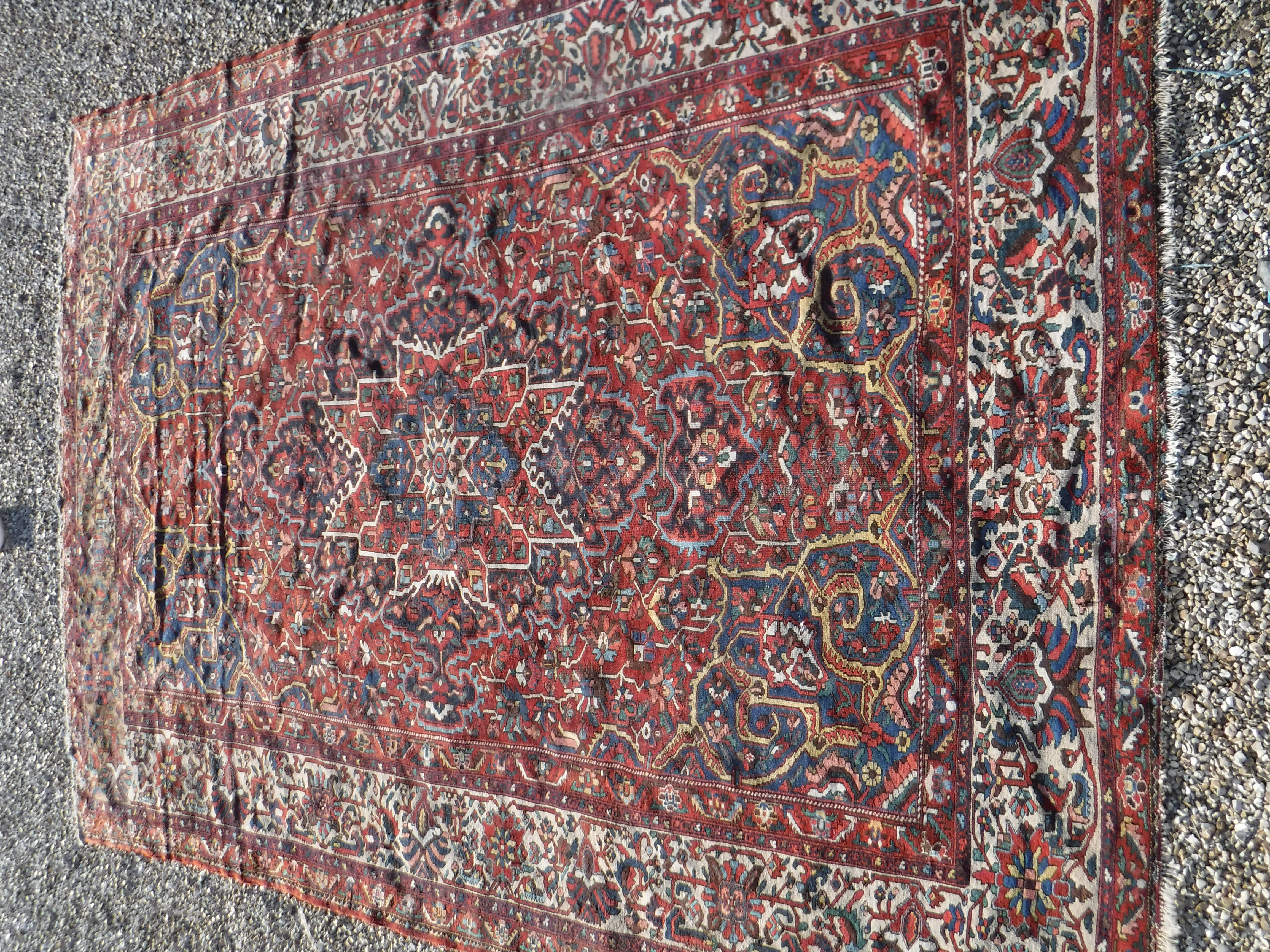 A Persian rug with centre medallion on a red ground and all over floral decoration within a cream - Image 2 of 3