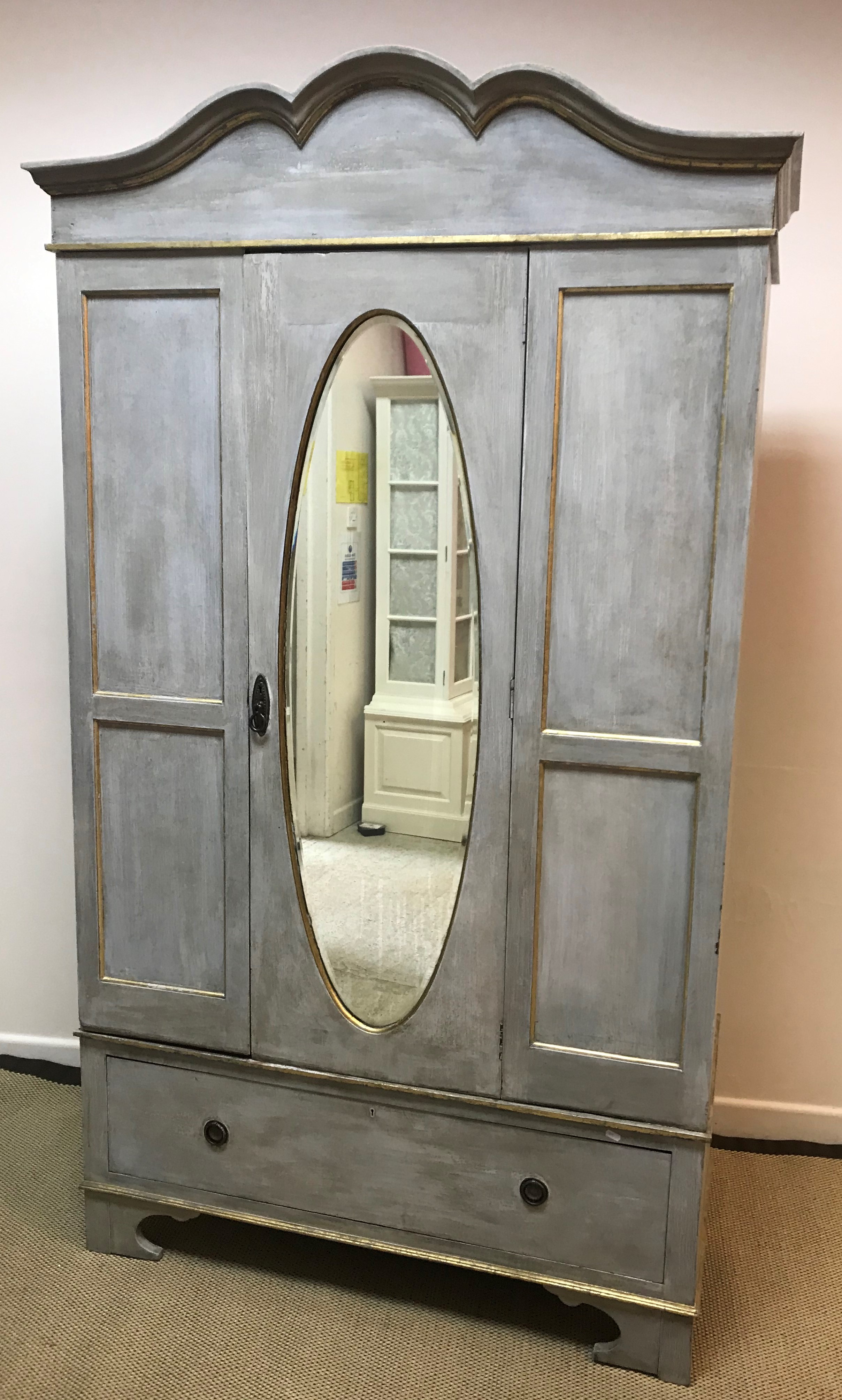 A painted and gilded single mirror door wardrobe with single drawer, raised on bracket feet,