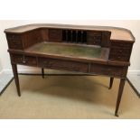 An early 20th Century mahogany Carlton House desk, the curved superstructure with various drawers,