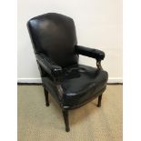 A Victorian walnut framed open arm chair, the black leatherette back,