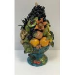 A Rosie Jackson pottery table centre heavily laden bowl of exotic fruits, the bowl with relief work,