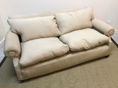 A circa 1900 fawn upholstered three-seat sofa on square tapered front legs (castors missing),