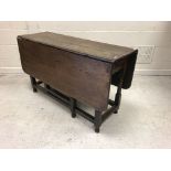 A 20th Century oak rectangular drop-leaf gate-leg dining table with single end drawer in the 18th