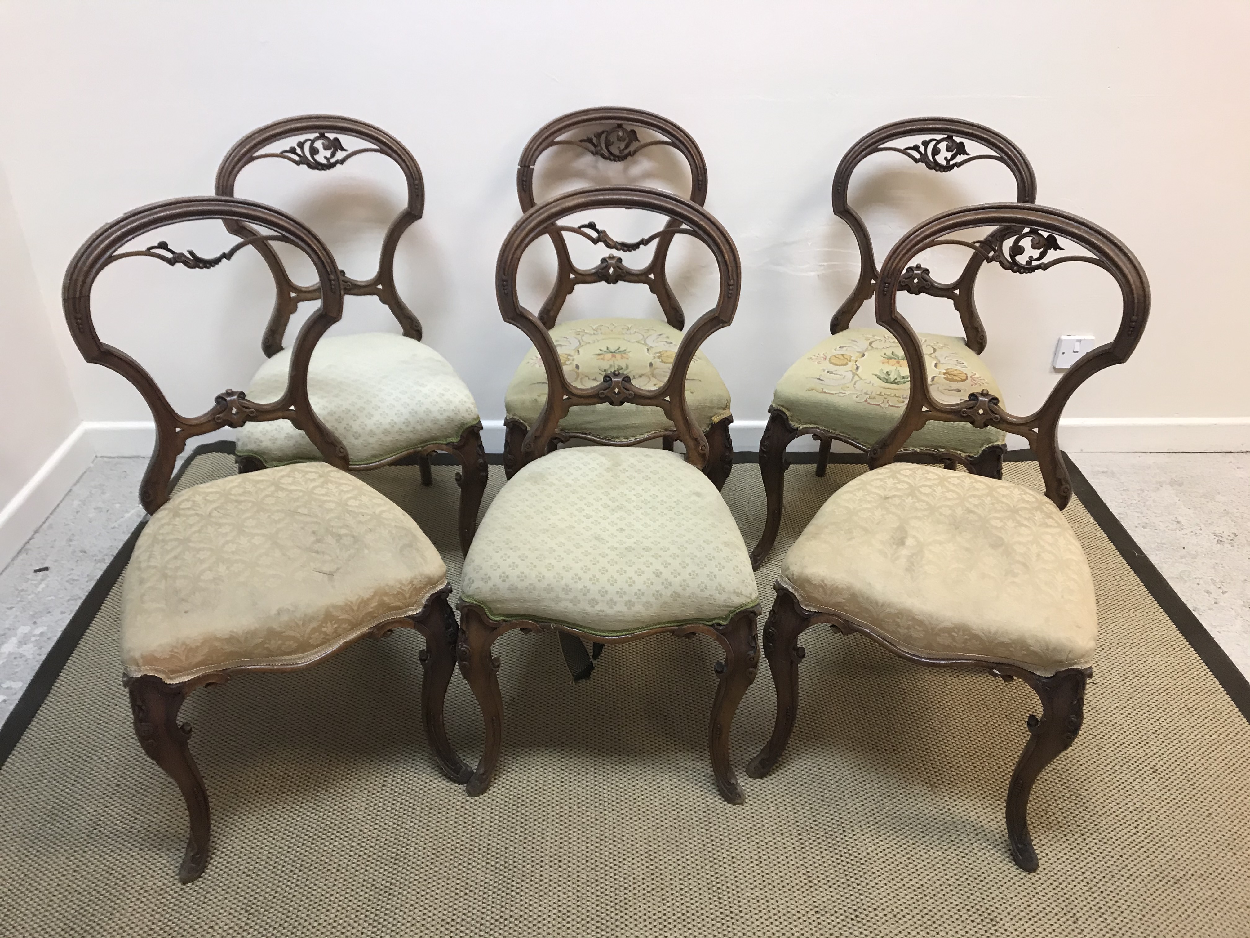 A set of six Victorian walnut framed shaped balloon back dining chairs with upholstered seats on
