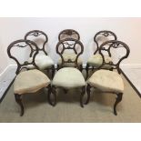 A set of six Victorian walnut framed shaped balloon back dining chairs with upholstered seats on