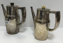 A pair of silver hot water jugs with hammered decoration and slender tapering spouts,