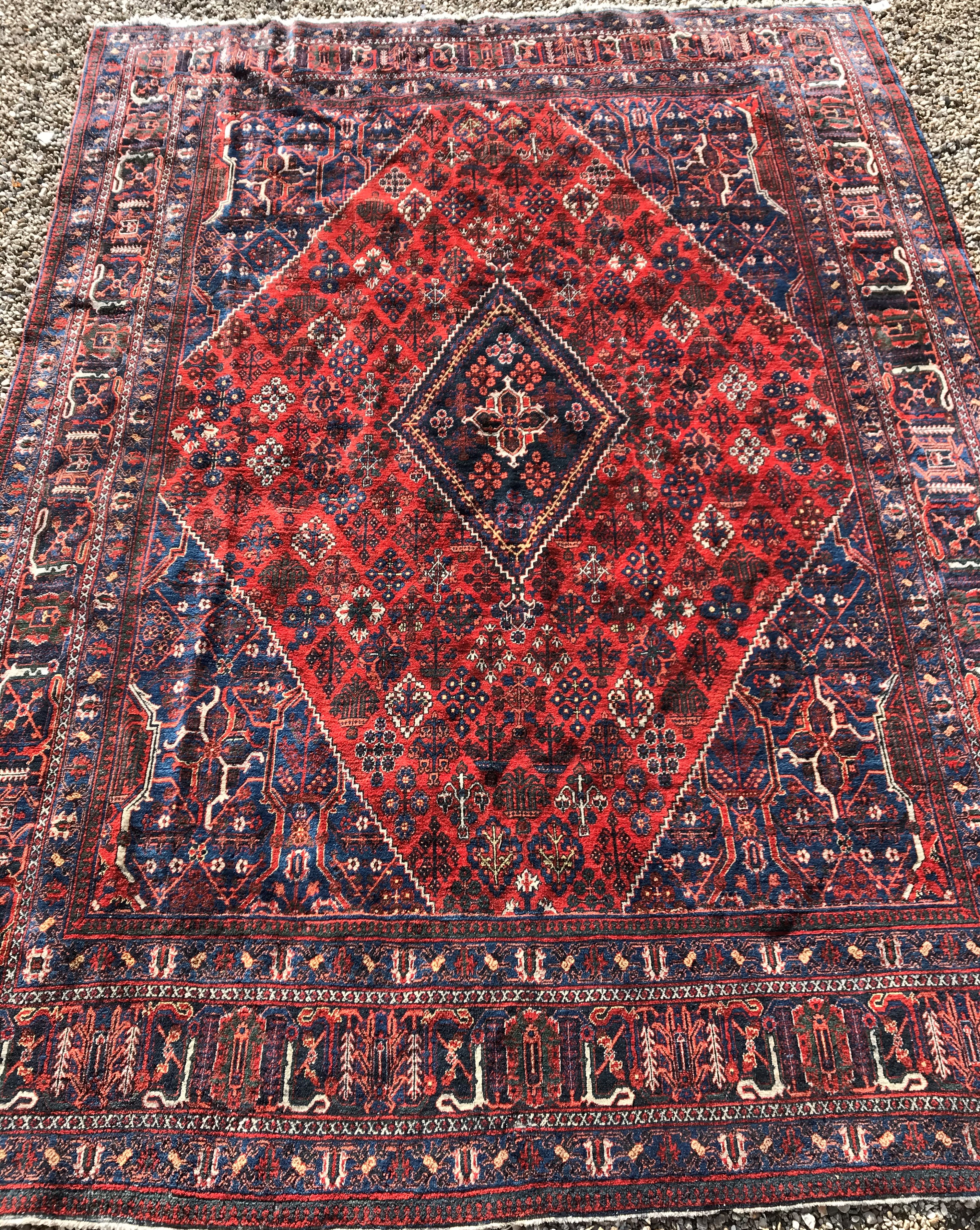 A Persian rug with all over floral decoration on a red ground,