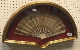 A circa 1900 Indian carved bone silk and metal work decorated fan, framed and glazed, frame size 52.