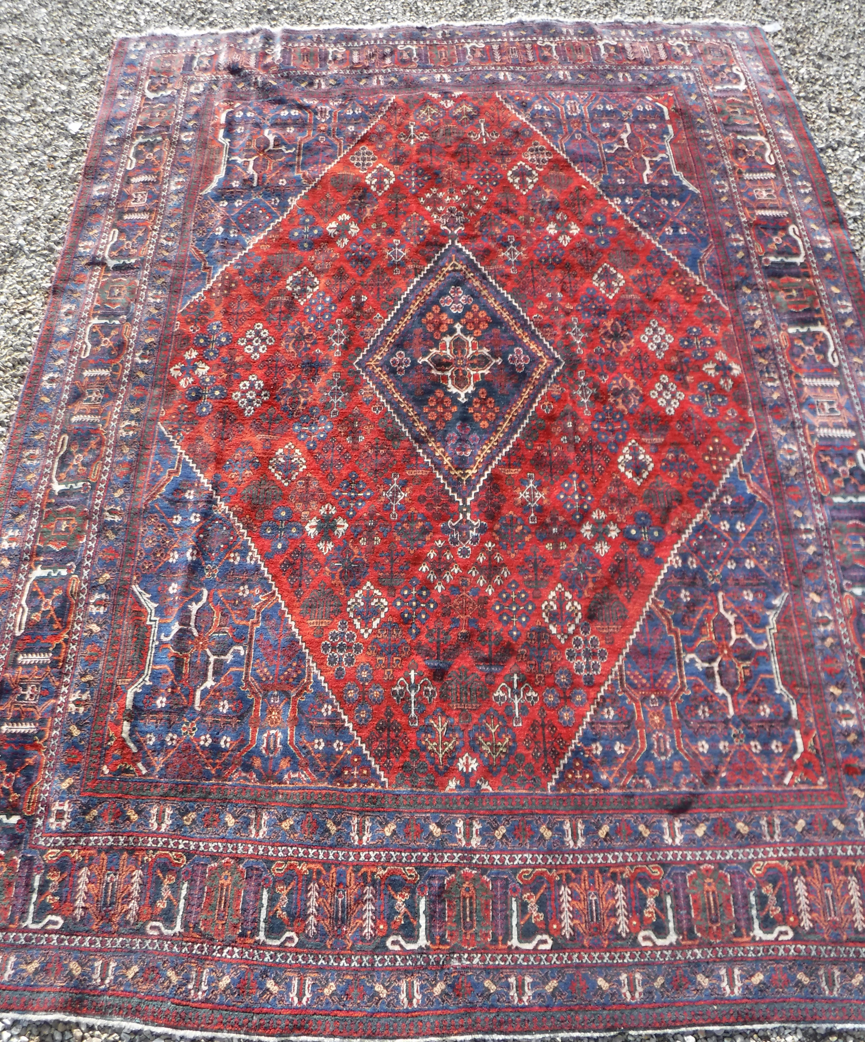A Persian rug with all over floral decoration on a red ground, - Image 2 of 5