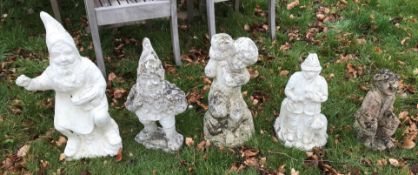 A collection of seven various concrete garden ornaments including gnome cobbler, gnome with basket,