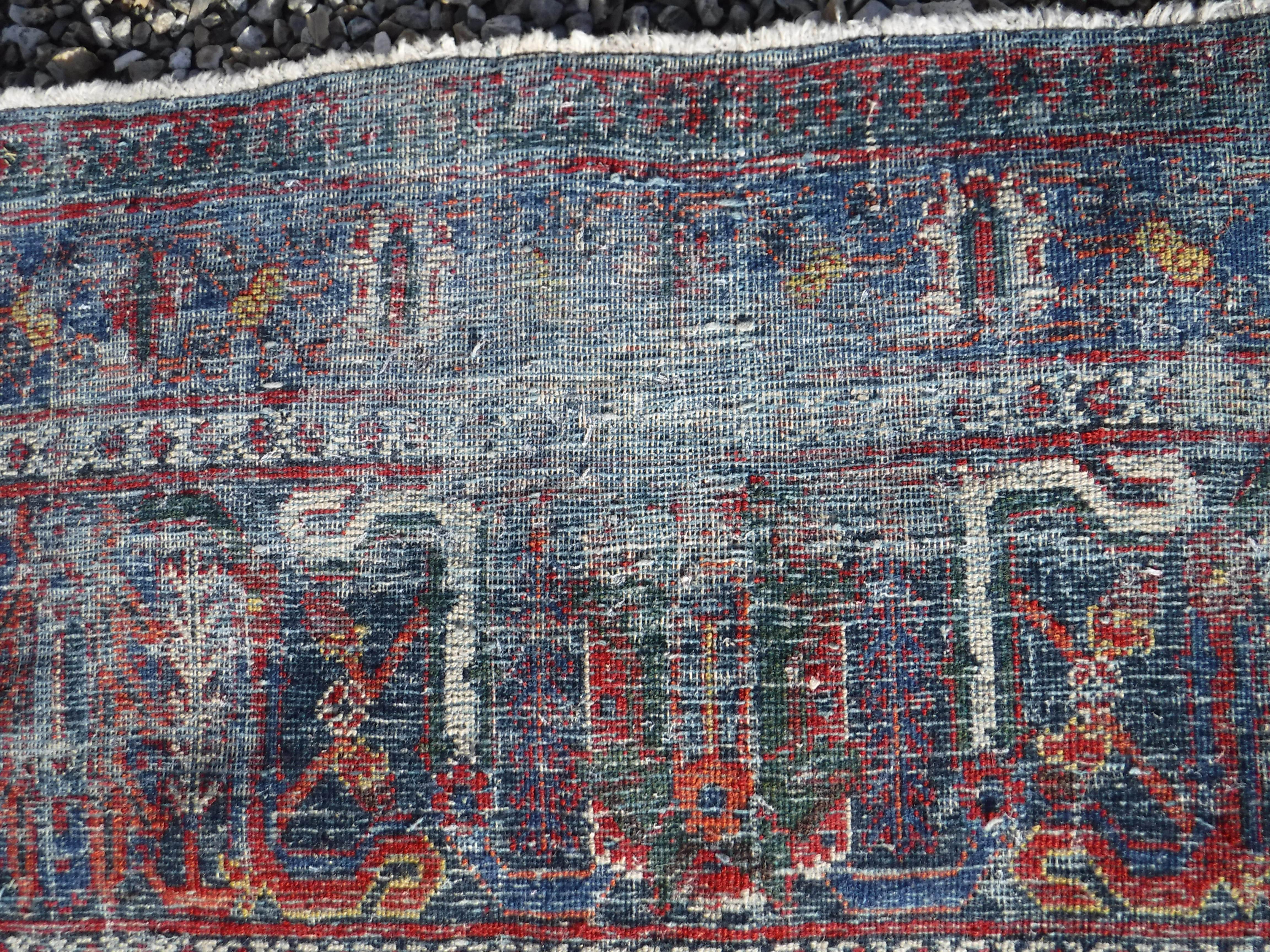 A Persian rug with all over floral decoration on a red ground, - Image 5 of 5