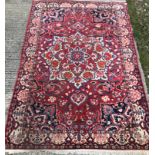 A Caucasian carpet, the central panel set with a flower head medallion on a red ground,