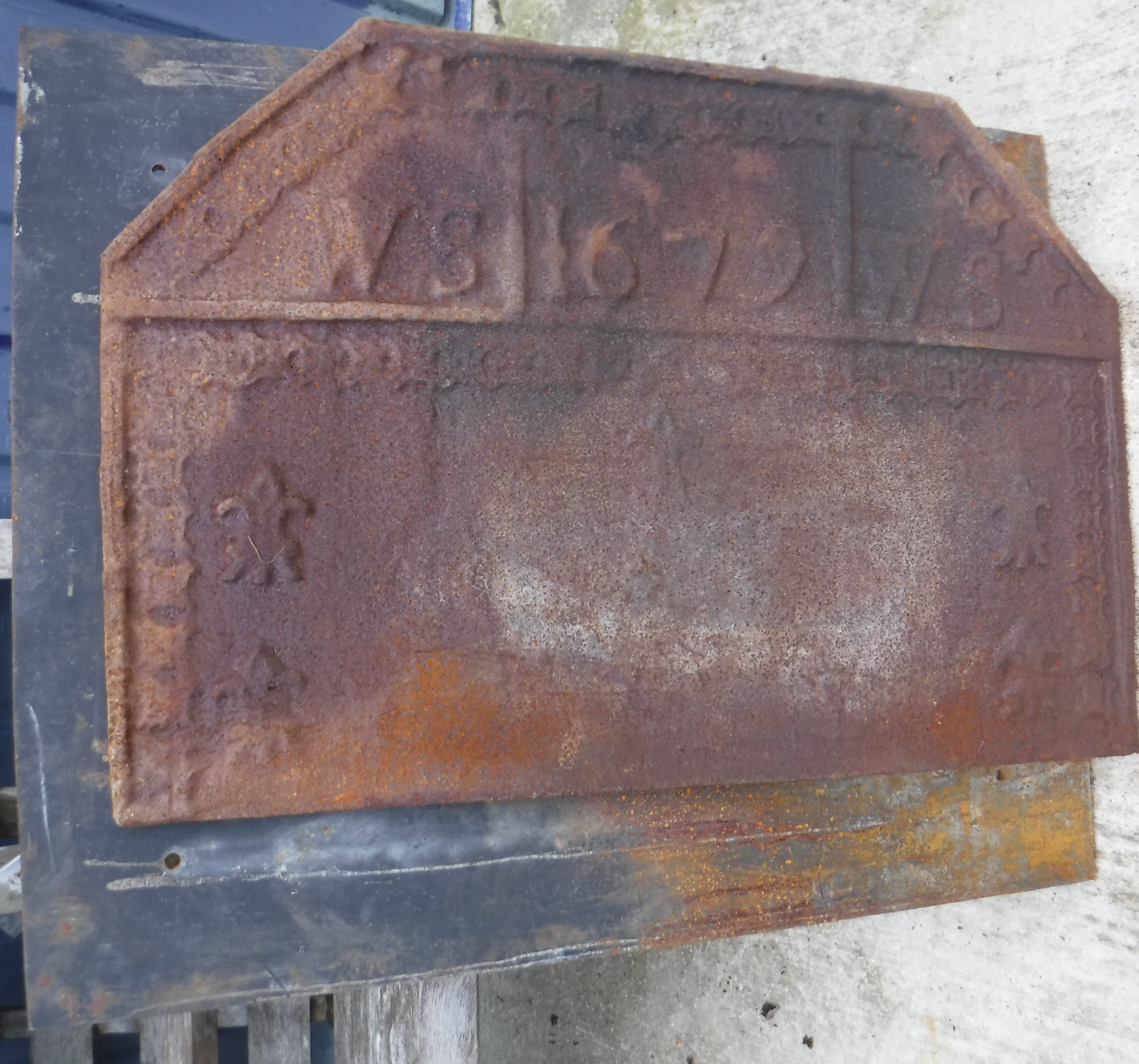 A cast iron fire back inscribed "1679",